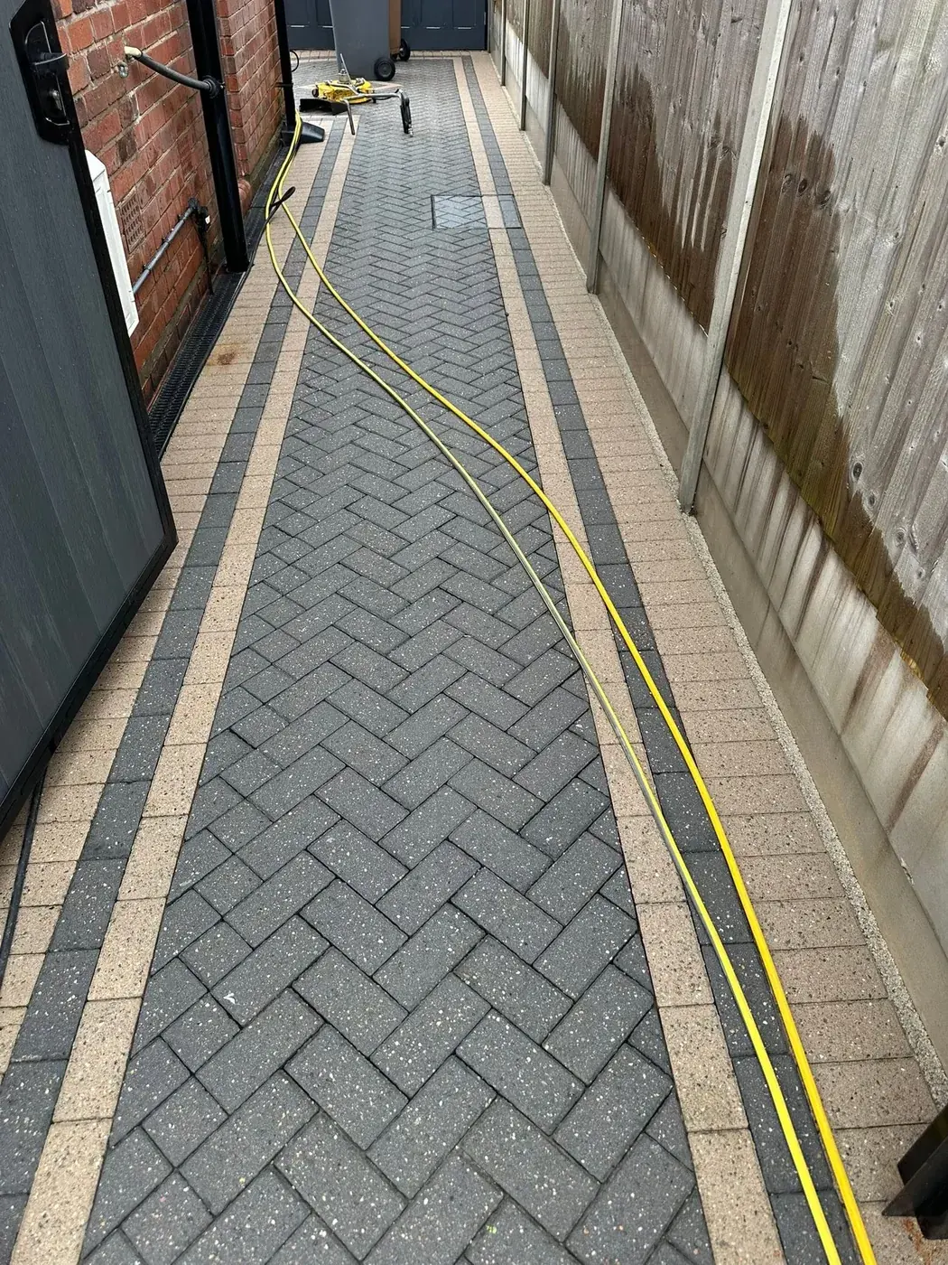 Cleaned block paving along the side of a home